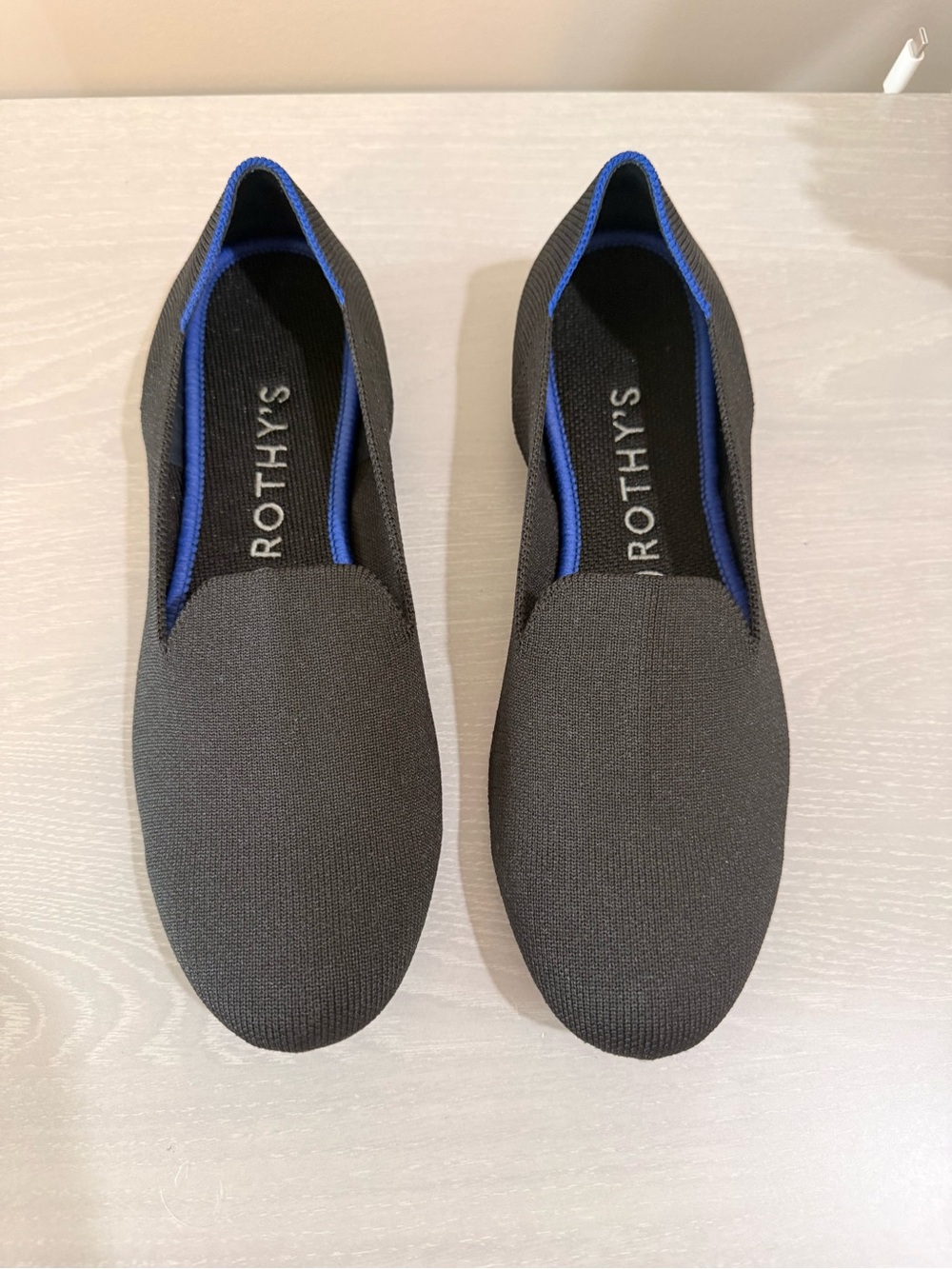 Rothy's Black Slip-On Flats with Blue Trim